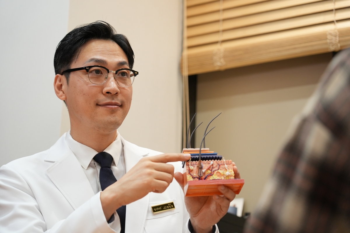 양민호 대표원장이 피부 단면 모형으로 피부 장벽의 구조를 설명합니다.